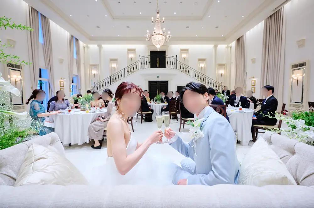 ソファの高砂で乾杯する新郎新婦