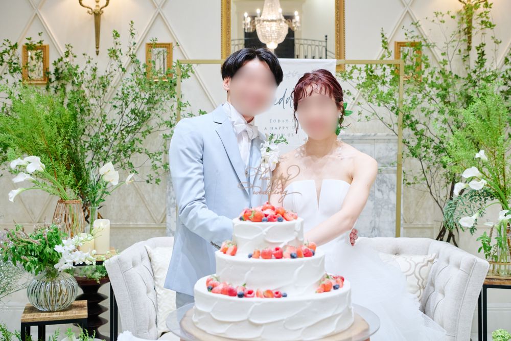ソファ高砂の前でウェディングケーキに入刀する新郎新婦